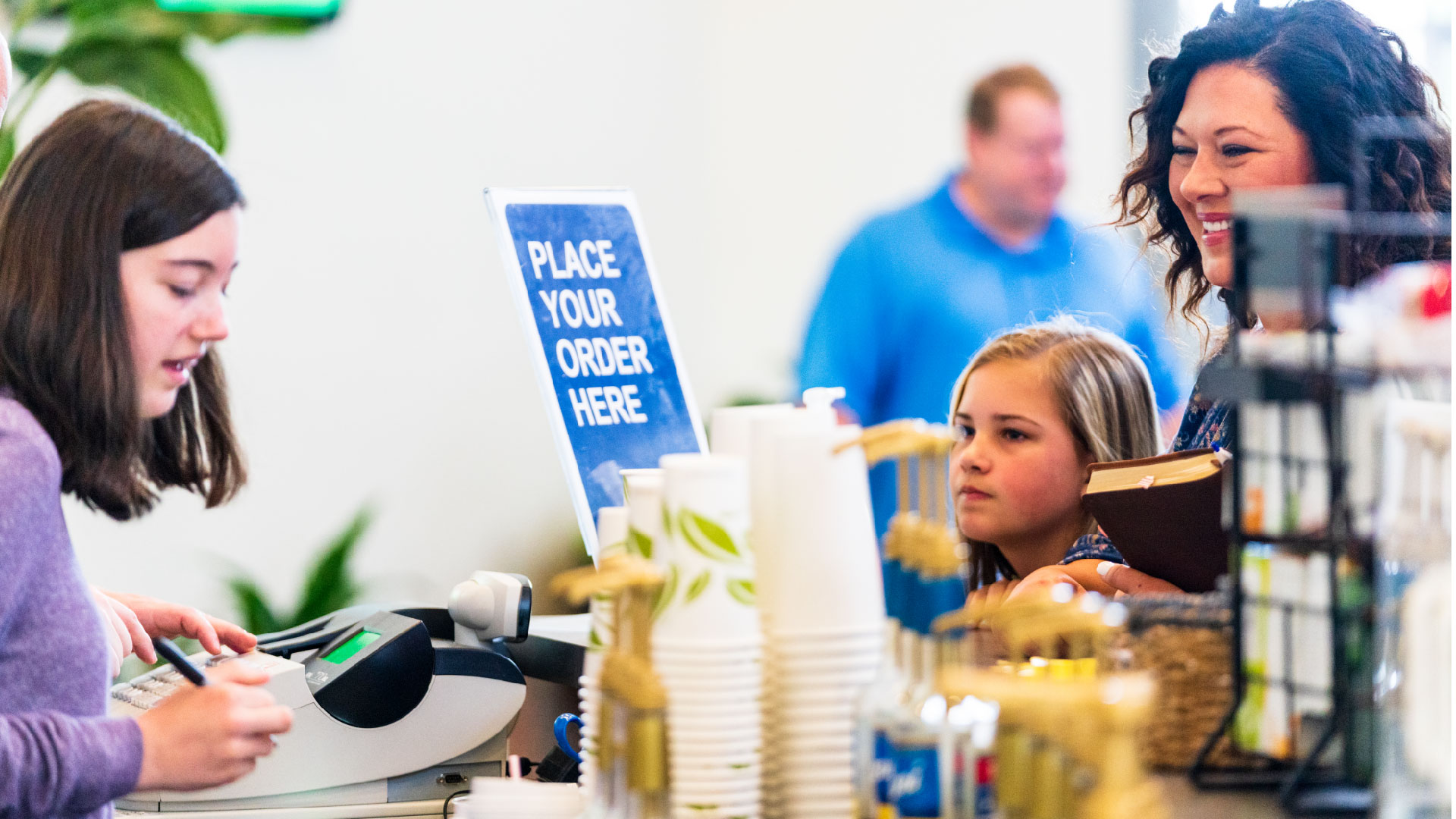 A brookwood Church volunteer takes a coffee order from a smiling